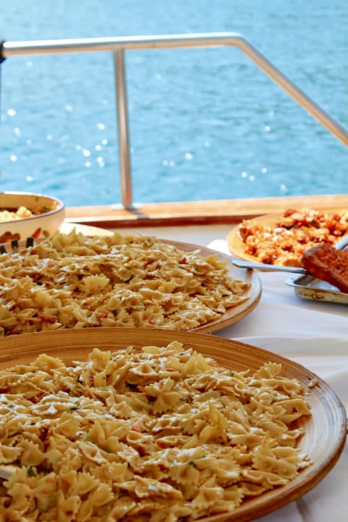 Piatti di pasta serviti sulla terrazza fronte acqua di Mappamondi BnB a Venezia, Italia
