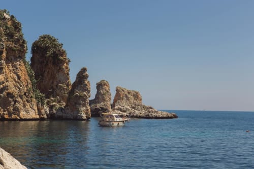 Spettacolari scogliere rocciose con barche in acque turchesi vicino a Venezia, Italia