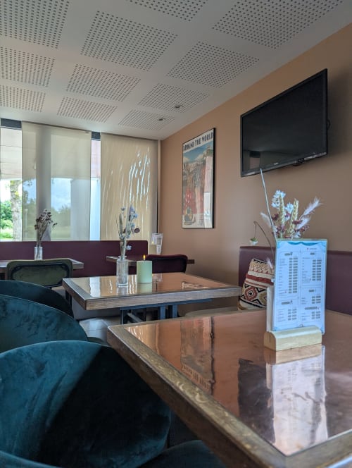Élégant salon moderne de La Verriaire avec sièges confortables, écran plat et fleurs décoratives à Chanverrie