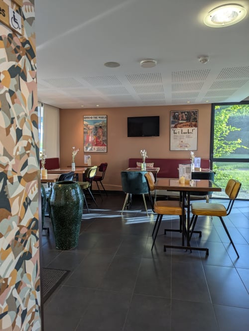 Espace lounge contemporain à l'hôtel La Verriaire à Chanverrie avec mobilier élégant, art géométrique mural et vues sur la nature