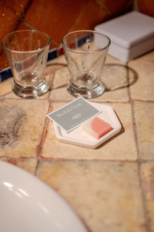 Elegant table setting at Mas Bella Cortis with water glasses, personalized name card, and coral soap on stone tiles in La