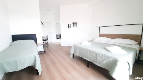 Camera moderna del B&B Bari Centro con due letti, biancheria bianca, testate in legno e arredamento minimalista a Bari, Italia