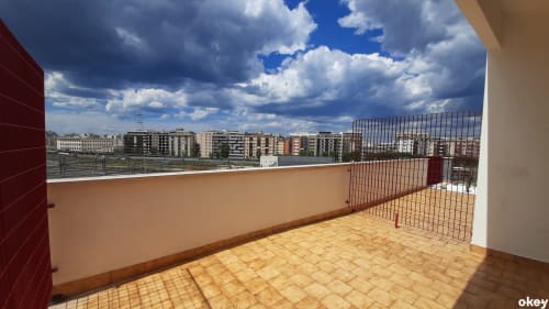 Terrazza soleggiata al B&B Bari Centro con vista della città e appartamenti di Bari sotto un cielo nuvoloso azzurro