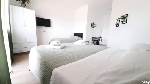 Camera moderna al B&B Bari Centro con letti gemelli, armadio bianco, TV a schermo piatto e arredamento minimalista a Bari