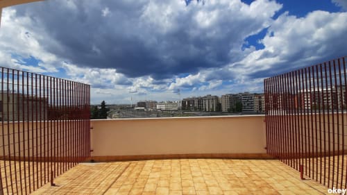 Ampio terrazzo panoramico del B&B Bari Centro con vista skyline, ringhiere marroni e cielo nuvoloso drammatico