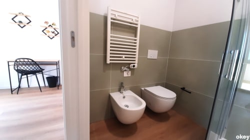 Bagno moderno del B&B Bari Centro con bidet e WC bianchi, scaldasalviette, pavimento in cotto