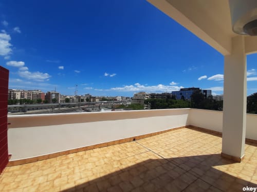 Ampia terrazza con pavimento piastrellato con vista sul panorama di Bari, muri bianchi, colonna e cielo azzurro al B&B Bari Centro