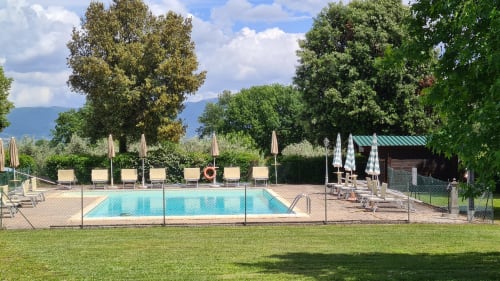 Piscina Agriturismo Buriano con lettini, ombrelloni e paesaggio rurale italiano a Lubriano