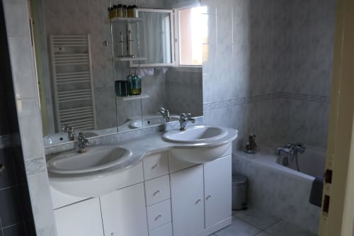 Salle de bain moderne de la Villa Eva gérée par la conciergerie Corsu Di Core avec double vasque, marbre, miroir armoire et baignoire vue mer