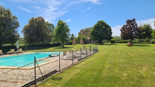 Giardino dell'Agriturismo Buriano con piscina, prati curati e alberi a Lubriano, Italia