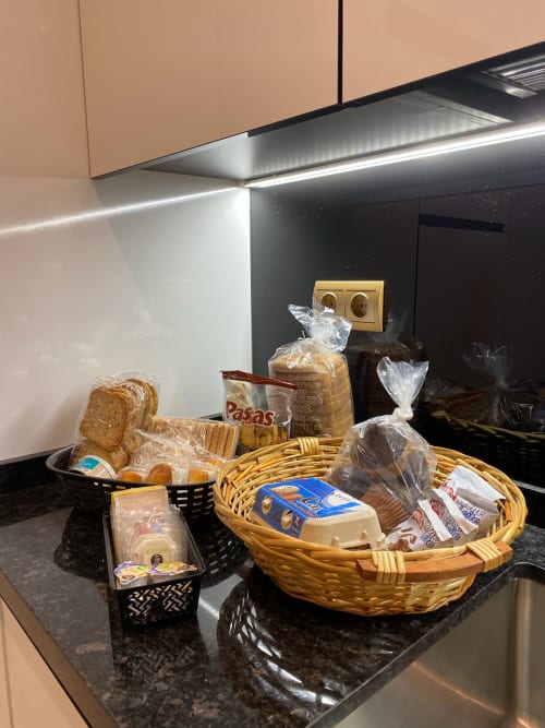 Continental breakfast baskets with bread, pastries, and spreads in Sevilla hotel suite kitchen
