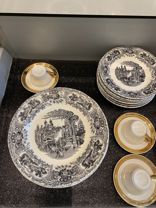 Fine dinnerware set with black toile plates and gold-rimmed cups at Edificio San Esteban 16 in Seville