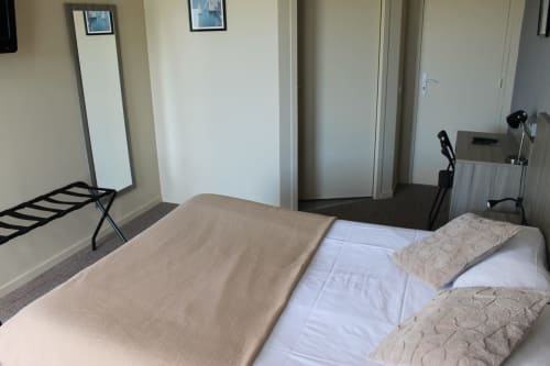 Chambre accessible à Libre Hôtel La Vespière avec lit, miroir, espace de travail et vue sur le jardin