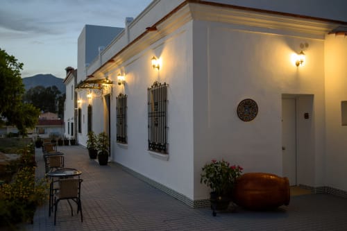 Terraza nocturna del Hotel Boutique Alcazaba Salobreña con muros blancos, iluminación cálida y vistas a las montañas de Granada, España