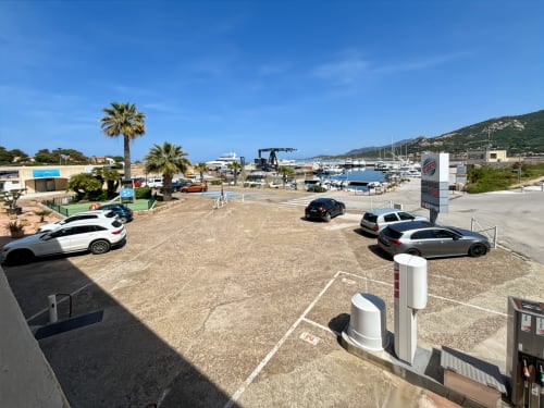 Parking du port de L'Île-Rousse avec bateaux et vue sur la mer Méditerranée