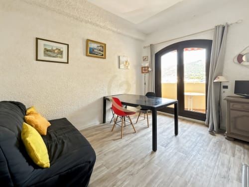 Lumineux T3 avec vue mer à L'Île-Rousse, séjour canapé noir, salle à manger, accès balcon