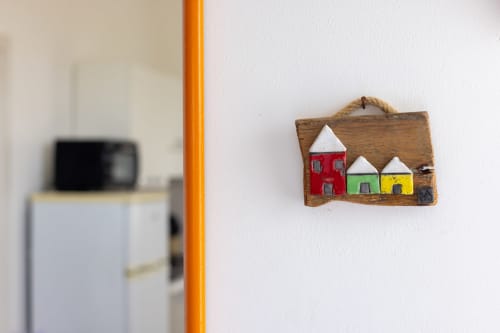 Colorful wooden house decoration on white wall at Senia del Rais B&B in Favignana, Italy