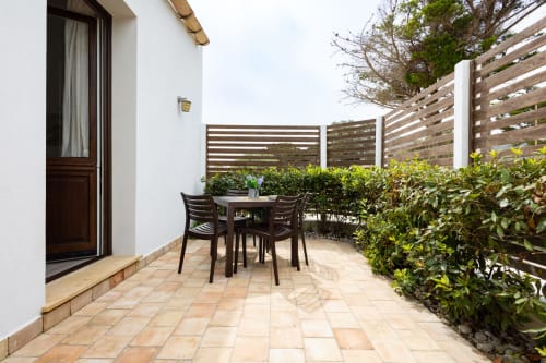 Private terrace at Senia del Rais B&B in Favignana with dining table, lounge chairs, and hedges