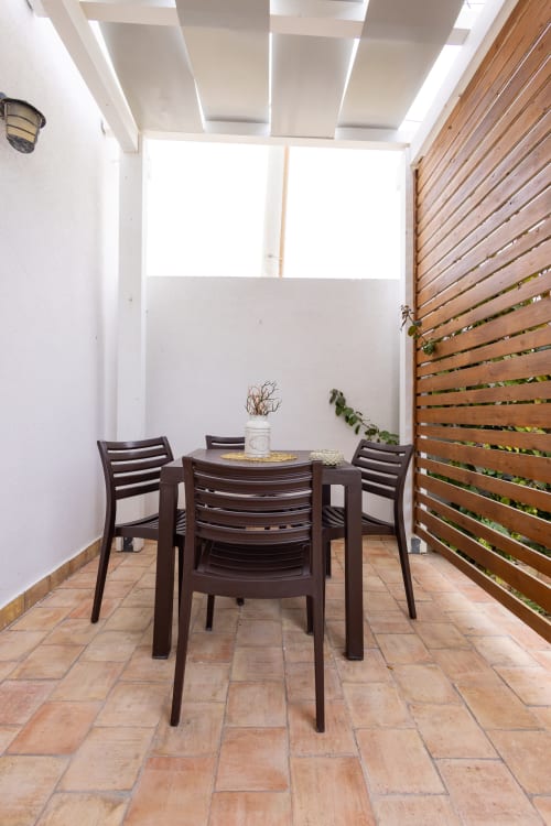 Private outdoor dining area at Senia del Rais in Favignana with dark furniture and wooden privacy screen