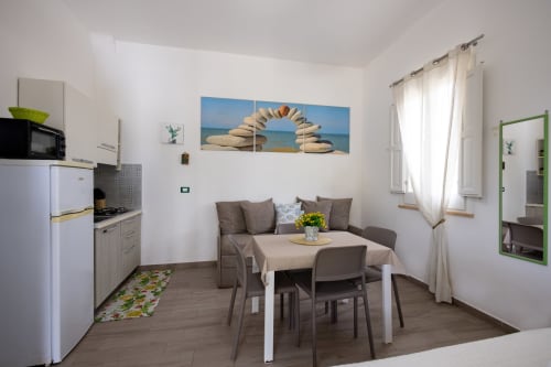 Medusa apartment at Senia del Rais B&B in Favignana with kitchenette, dining area, sofa, and beach-themed decor