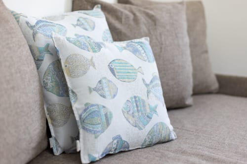 Decorative fish-patterned pillows on a beige sofa in the Medusa apartment at Senia del Rais, Favignana