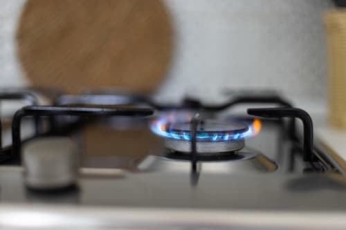 Gas stove burner with blue flame in Medusa apartment kitchen at Senia del Rais, Favignana