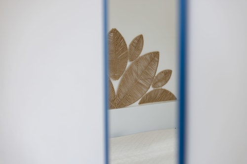 Decorative wooden leaf wall art in Stella Marina room at Senia del Rais, Favignana