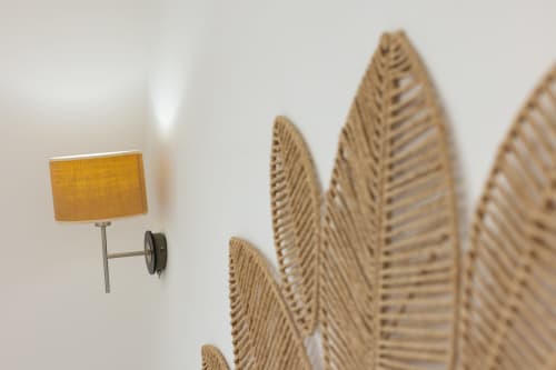 Woven wall decoration and yellow lamp in Stella Marina room at Senia del Rais, Favignana