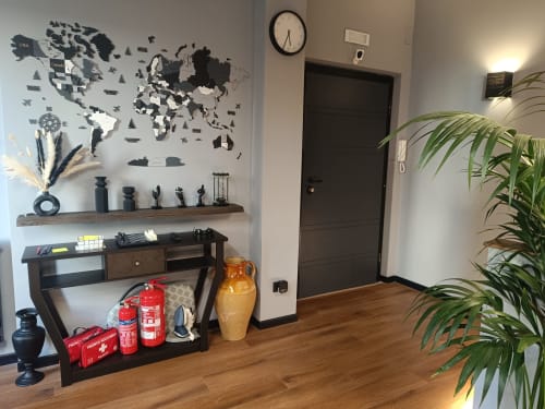 Ingresso moderno di camera B&B a Roma con cartina mondiale, scrivania in legno, piante e attrezzature di sicurezza