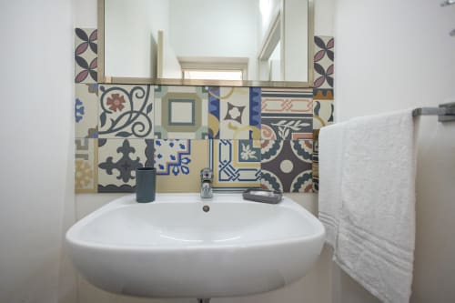 Modern bathroom sink with decorative patterned tile backsplash at Senia del Rais, Favignana