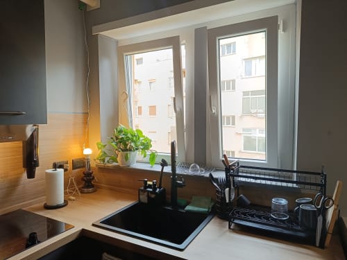 Cucina moderna con vista sulla città a Trastevere Noir BnB a Roma, con lavello, fornello e piano di lavoro organizzato.