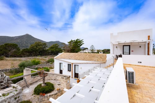 Senia del Rais B&B in Favignana: white terracotta-roofed room with sea view overlooking mountains and Mediterranean landscape