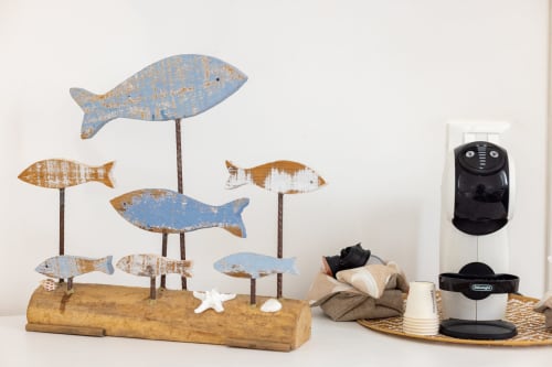 Coastal decor in Favignana room: wooden fish sculptures and coffee station with sea-view aesthetic
