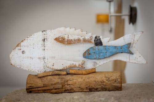 Handcrafted wooden whale decoration with white and blue fish accents on driftwood base at Senia del Rais, Favignana