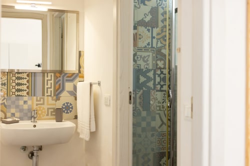 Modern bathroom in Sardina apartment at Senia del Rais, Favignana, featuring decorative tilework and walk-in shower