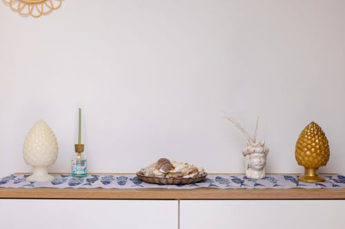 Decorative shelf display with ceramic and brass pineapples, white head planter, and natural accents in Sardina apartment at