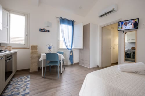 Bright studio apartment at Senia del Rais in Favignana with bed, dining table, kitchenette, and mountain views
