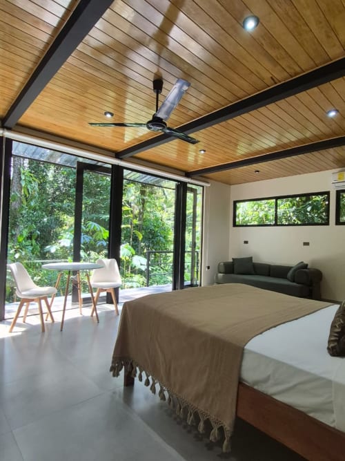 Habitación Morpho en Fauna Lodge con cama, balcón con vista a la selva tropical, techo de madera y mobiliario moderno