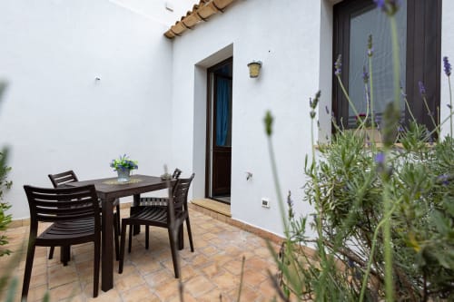 Outdoor dining terrace at Senia del Rais, Favignana with black table, chairs, and lavender plants