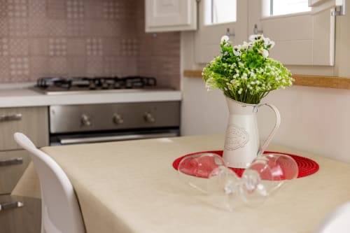 Kitchen dining area in Tartaruga Marina apartment at Senia del Rais, Favignana with white flowers in pitcher on table