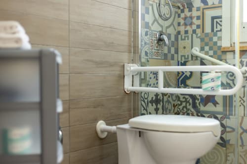 Bathroom with white toilet, towel rack, and decorative blue patterned tiles at Senia del Rais in Favignana