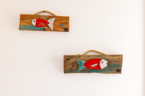 Two wooden wall plaques with red and white fish decorations, nautical decor in Tartaruga Marina apartment, Favignana