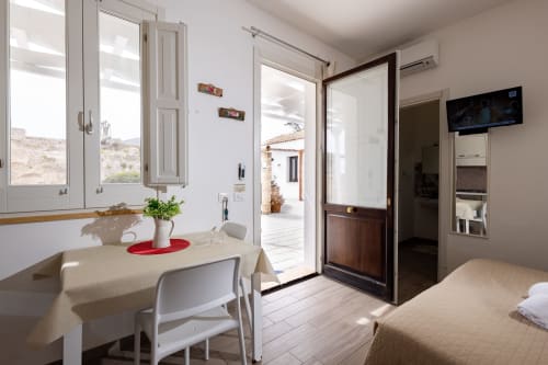 Bright apartment studio at Senia del Rais in Favignana with dining area, bed, ocean view windows, and modern amenities