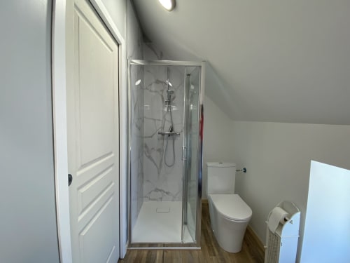 Modern en-suite bathroom with shower, toilet, and wooden flooring in Studio confort cottage at Domaine des Piéris,