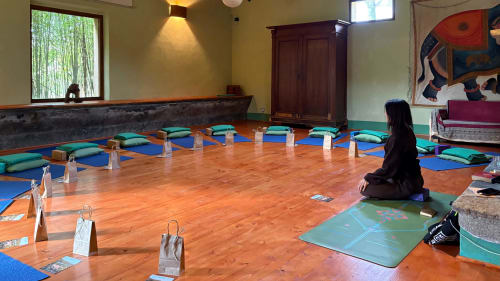 Yogastudio in Podere di Maggio B&B in Santa Fiora met meditatiekussens, blauwe matten en houten vloeren
