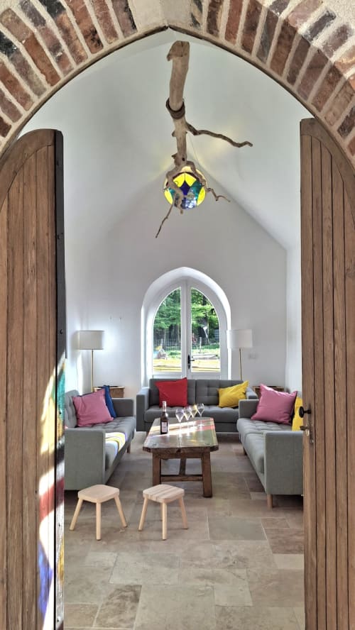 Élégant salon aménagé dans une chapelle au Château de la Malmaison, avec plafond voûté, mobilier contemporain et lumière naturelle