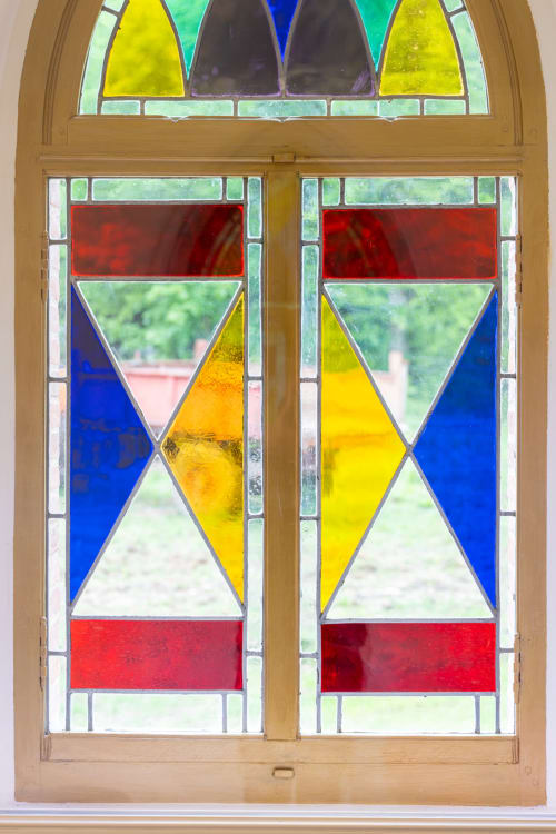 Porte en vitrail du Château de la Malmaison avec motifs géométriques en verres rouges, jaunes et bleus