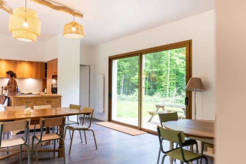 Espace cuisine et salle à manger moderne de la villa La Chapelle au Château de la Malmaison, Aÿ-Champagne, avec luminaires suspendus tissés et