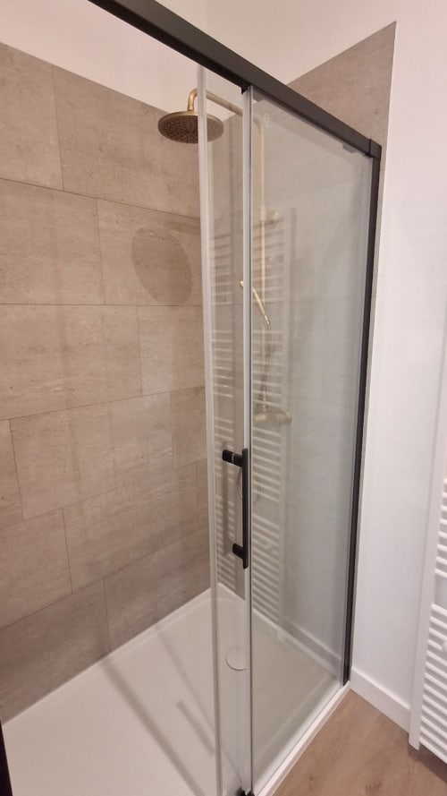 Douche moderne avec paroi vitrée et pomme de douche effet pluie dans la salle de bain de la villa La Chapelle du Château de La Malmaison