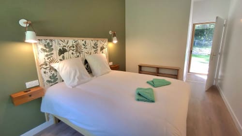 Chambre lumineuse au Château De La Malmaison en Champagne, avec murs verts, tête de lit botanique et accès à la terrasse